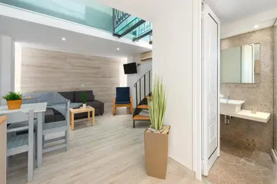 a living room and kitchen with a couch and a sink at Pefkos View Suites & Maisonette in Pefki Rhodes