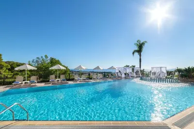 a large swimming pool with chairs and umbrellas at Pefkos View Suites & Maisonette in Pefki Rhodes