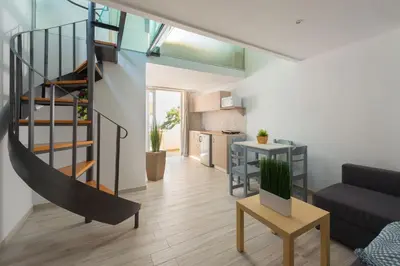 a living room with a spiral staircase in a apartment at Pefkos View Suites & Maisonette in Pefki Rhodes