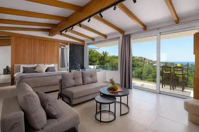 a living room with a bed and a couch at Pefkos View Suites & Maisonette in Pefki Rhodes