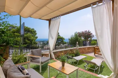 a patio with a couch and chairs and a table at Pefkos View Suites & Maisonette in Pefki Rhodes