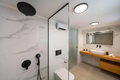 a bathroom with a glass shower and a sink at Gioiello Villa in Pefki Rhodes