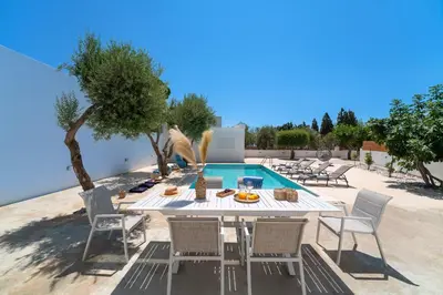 a patio with a table and chairs next to a pool at Gioiello Villa in Pefki Rhodes