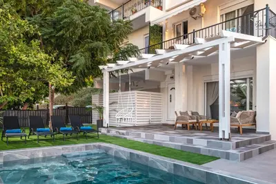 a pergola over a swimming pool in front of a house at Paradissia Luxe Villa with Private Swimming Pool in Paradeísion