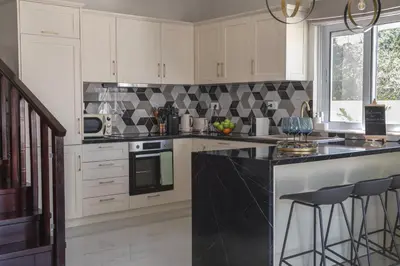 a kitchen with white cabinets and a black counter top at Paradissia Luxe Villa with Private Swimming Pool in Paradeísion