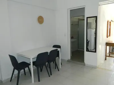 a dining room with a white table and chairs at Roseberry Studios in Faliraki