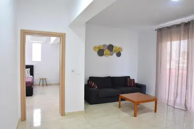 a living room with a black couch and a table at Roseberry Studios in Faliraki