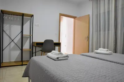 a bedroom with two beds and a desk and a chair at Roseberry Studios in Faliraki