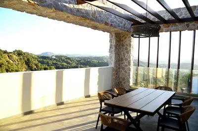 a dining room with a table and chairs on a balcony at Villa 101 Rhodes in Ixia