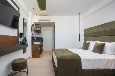 a hotel room with a bed and a television at Ermou 44 City Hotel in Faliraki