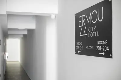 a sign hanging on a wall in a hallway at Ermou 44 City Hotel in Faliraki