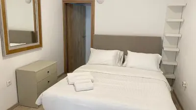 a bedroom with a bed with white sheets and a mirror at Rhodes Beach Side Houses in Ixia