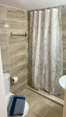 a bathroom with a shower curtain and a toilet at Rhodes Beach Side Houses in Ixia