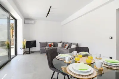a living room with a table and a couch at Villa Zen Zazan by Villa Plus in Kolimbia