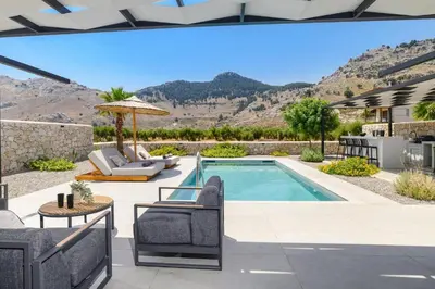 a swimming pool with chairs and a table and a patio at Villa Zen Zazan by Villa Plus in Kolimbia