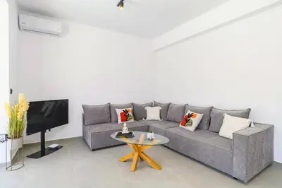 a living room with a gray couch and a table at Villa Zen Zazan by Villa Plus in Kolimbia