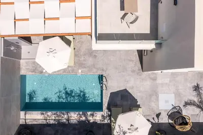an overhead view of a swimming pool with umbrellas at Aura Luxury Villas in Kolimbia
