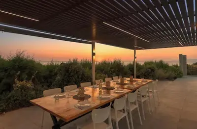 a long wooden table and chairs on a patio at Villa Ramann, Rhodes in Rhodes Town