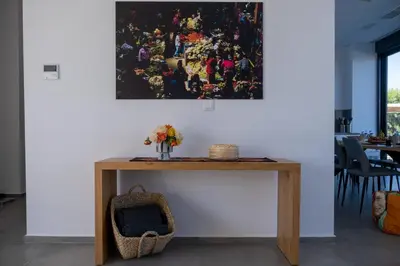 a table with flowers and a painting on the wall at Villa Ramann, Rhodes in Rhodes Town