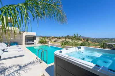 a swimming pool with a hot tub on a patio at Villa Trapezia Diamond in Kolimbia