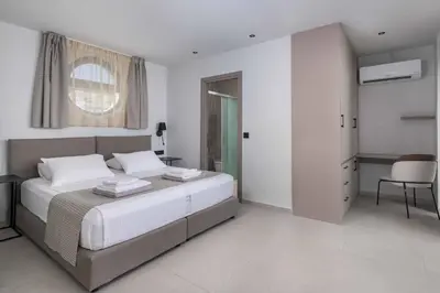 a bedroom with a bed and a table and a chair at Villa Trapezia Diamond in Kolimbia