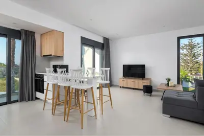 a kitchen and living room with a table and chairs at Davlakos Apartments Rea in Kremasti