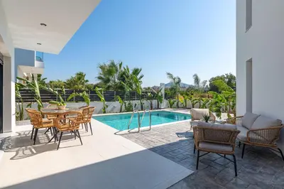 a patio with a table and chairs next to a pool at Davlakos Apartments Rea in Kremasti