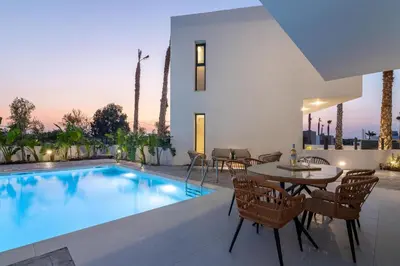 a villa with a swimming pool and a table and chairs at Davlakos Apartments Rea in Kremasti