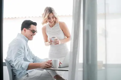 a man and woman sitting at a table with a cup of coffee at Aurora Living - Adults Only in Faliraki