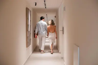 a man and a woman walking down a hallway at Aurora Living - Adults Only in Faliraki