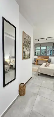 a white living room with a mirror and a bed at Spiti Studio City Center in Rhodes Town