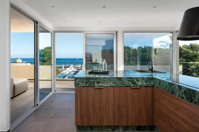 an open kitchen with a counter with a view of the ocean at Hamilton Elite Penthouse in Rhodes Town