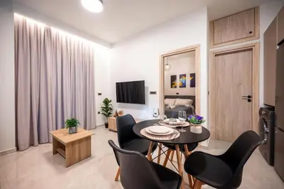 a living room with a dining room table and chairs at Corner Apartment in Ialyssos