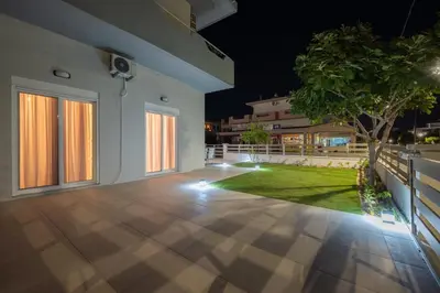 an empty house with a patio at night at Corner Apartment in Ialyssos