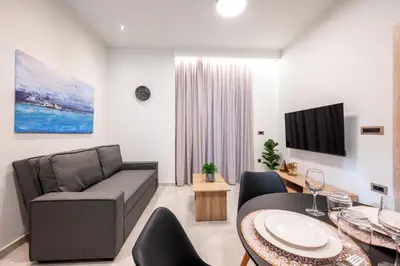 a living room with a couch and a table at Corner Apartment in Ialyssos