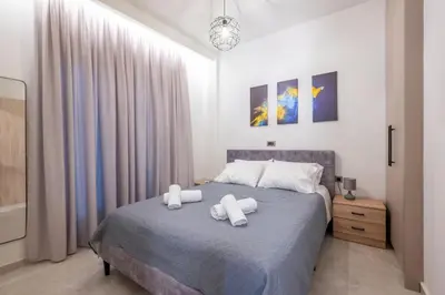 a bedroom with a bed with two towels on it at Corner Apartment in Ialyssos