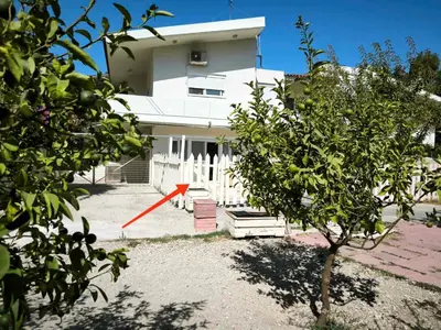 a white house with a red arrow in front of it at Costelia Studio in Ialyssos