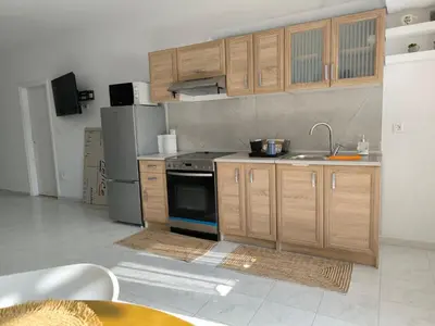 a kitchen with wooden cabinets and a sink and a stove at Costelia Studio in Ialyssos