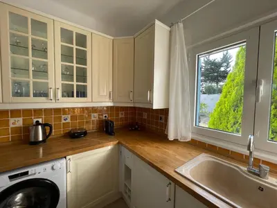 a kitchen with white cabinets and a sink and a window at Xenia Terra in Kiotari