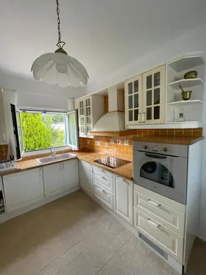 a kitchen with white cabinets and a window at Xenia Terra in Kiotari