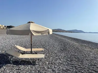 a pair of chairs and an umbrella on a beach at Xenia Terra in Kiotari