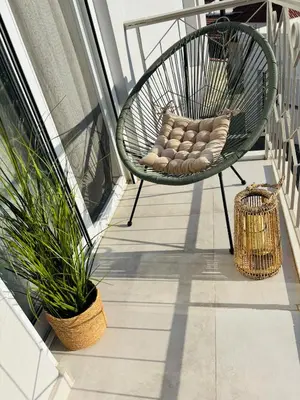 a green chair on a balcony with a plant at Maison de Léa in Sálakos
