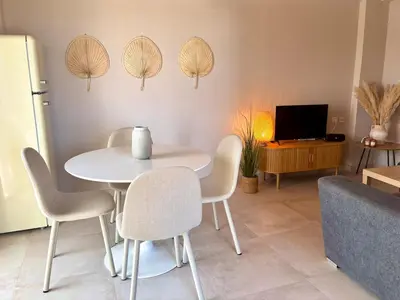 a dining room with a white table and chairs at Maison de Léa in Sálakos