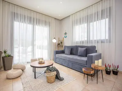 a living room with a blue couch and a table at 2-Bedroom Villa with Private Pool in Kalithies in Faliraki