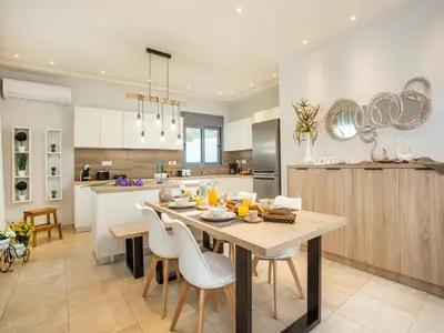 a kitchen and dining room with a table and chairs at 2-Bedroom Villa with Private Pool in Kalithies in Faliraki