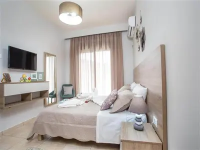a white bedroom with a bed and a television at 2-Bedroom Villa with Private Pool in Kalithies in Faliraki