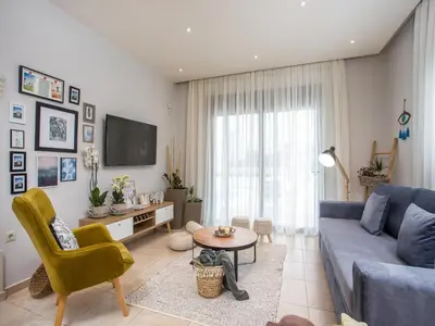 a living room with a blue couch and a table at 2-Bedroom Villa with Private Pool in Kalithies in Faliraki