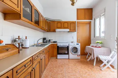 a kitchen with wooden cabinets and a washing machine at La Casa Lemonià in Soroni
