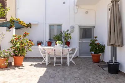 a patio with a table and chairs and potted plants at La Casa Lemonià in Soroni