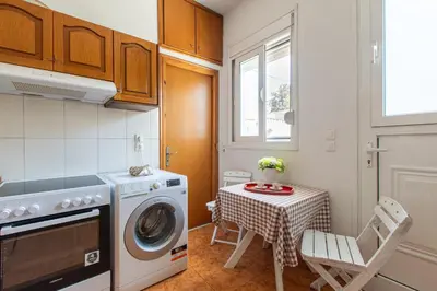 a kitchen with a washing machine and a table at La Casa Lemonià in Soroni